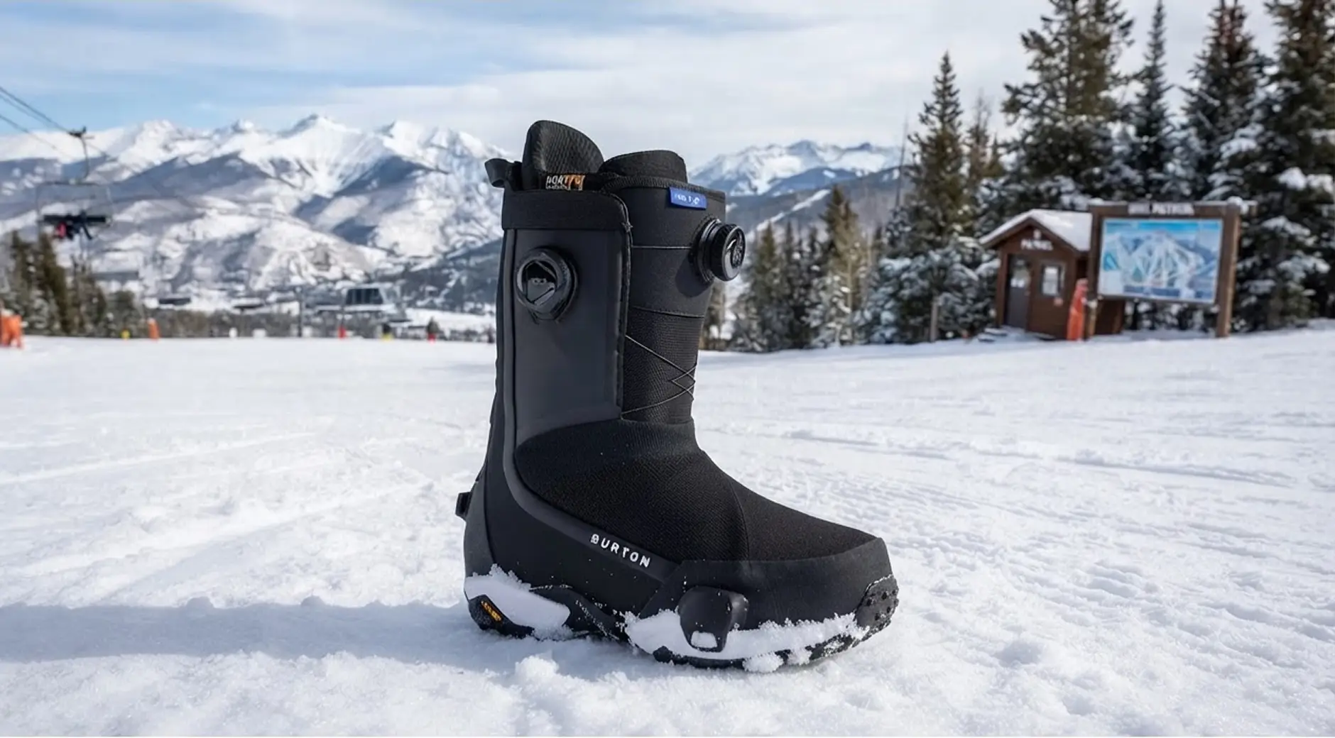 Burton snowboard boot standing in snow with mountain resort backdrop